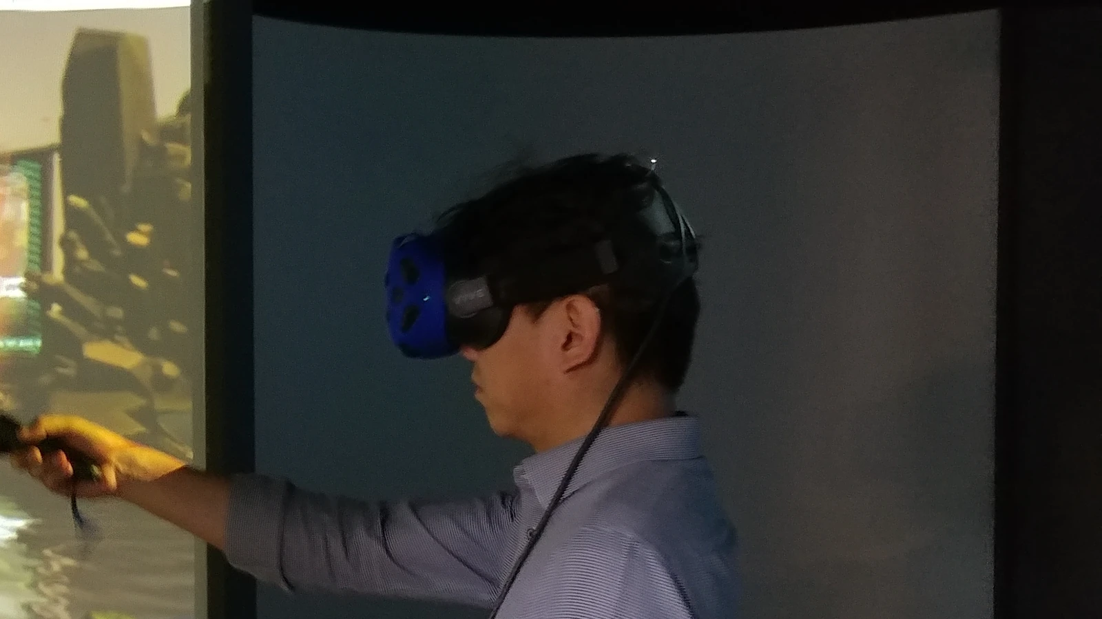 홍대 VR 경험 공간 곡면 스크린 앞의 VR 헤드셋 이용 장면